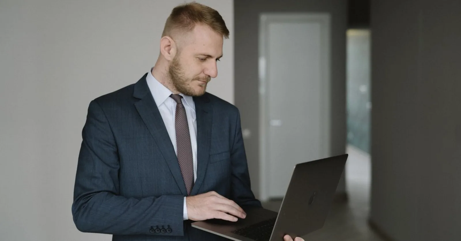 Corretor de terno usando notebook em escritório